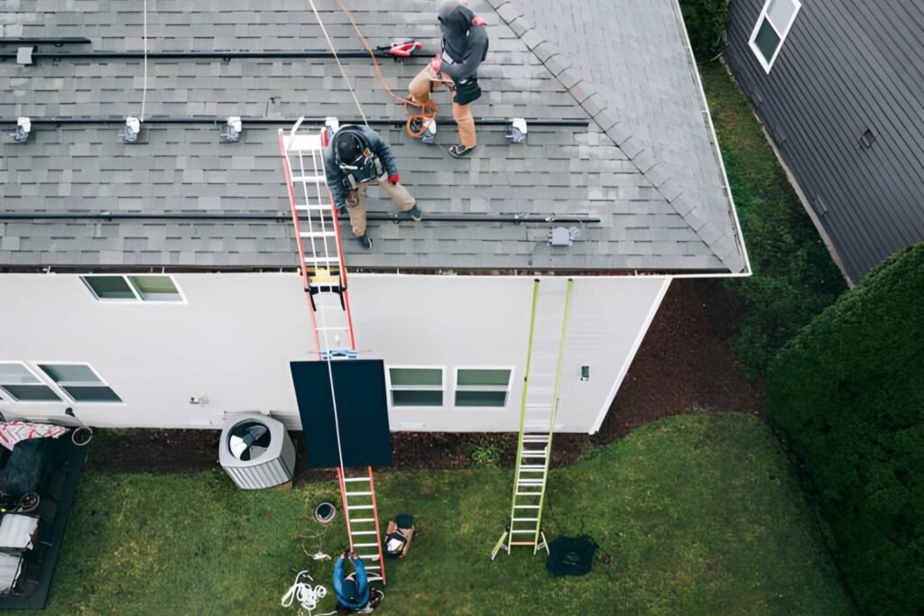 Aerial View of Solar Energy Technicians Working To Install Solar Panels on Residential Roof (2)
